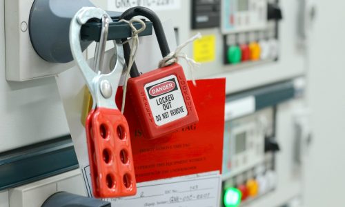 Red key lock and white tag for process cut off electrical on control panel in substation at chemical plants, power plants, oil & gas industry or onshore industry. isolation tag and do not remove tag.